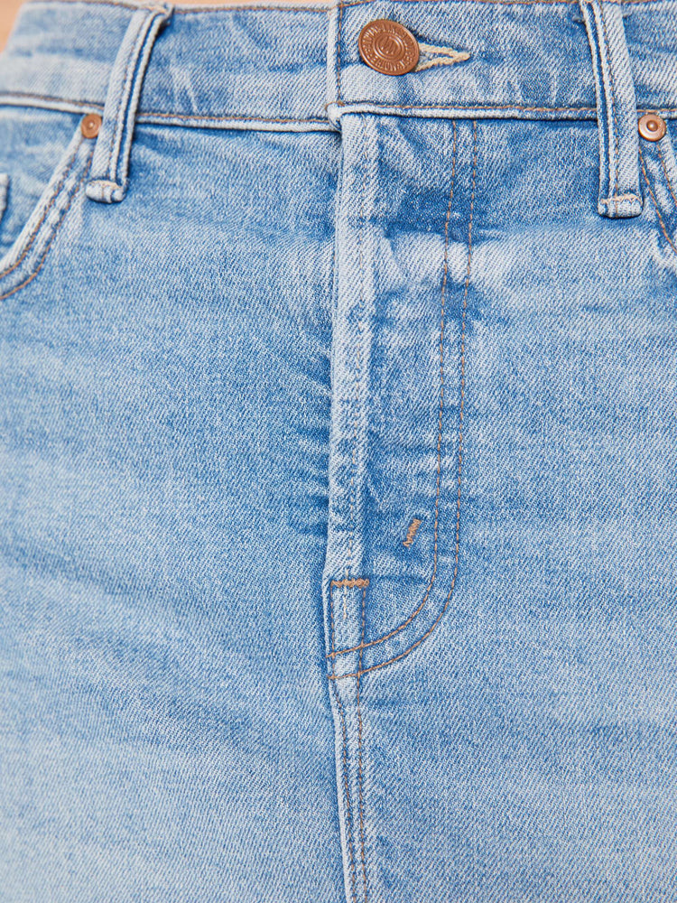 Close up swatch detail view of a light blue wash denim skirt.