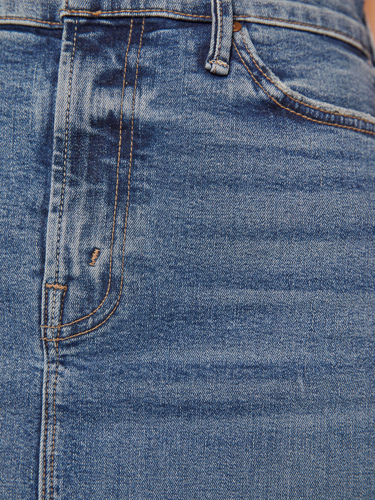 Swatch view of a woman high waisted denim midi skirt with an A-line fit and a clean hem that hits just below the knee in a mid-blue wash.