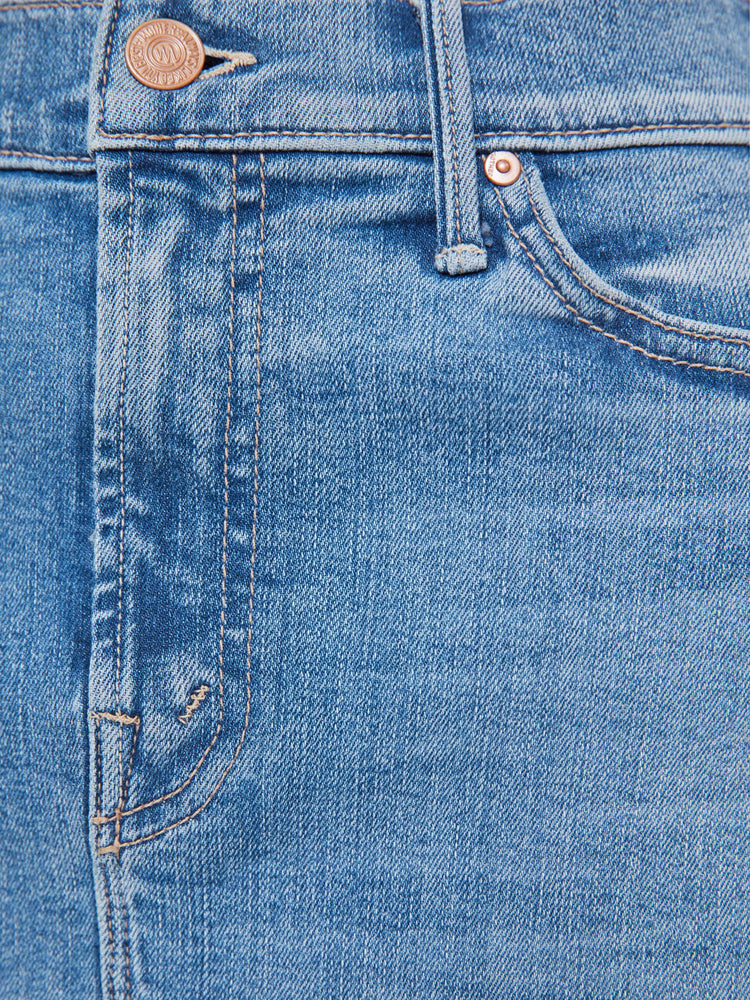Swatch view of a woman in a light blue  high-waisted denim midi skirt with a zip fly, A-line fit and calf-length hem. 