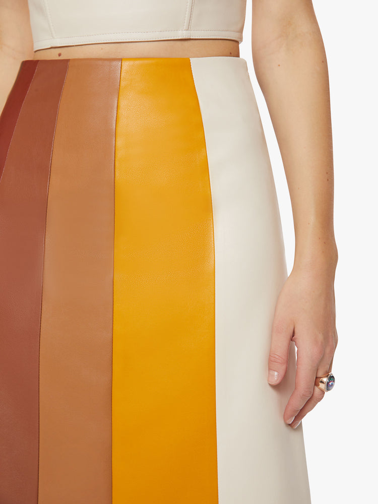 Close up view of a woman colorblocked midi skirt with a high rise, loose fit and a calf-grazing hem in a faux leather.