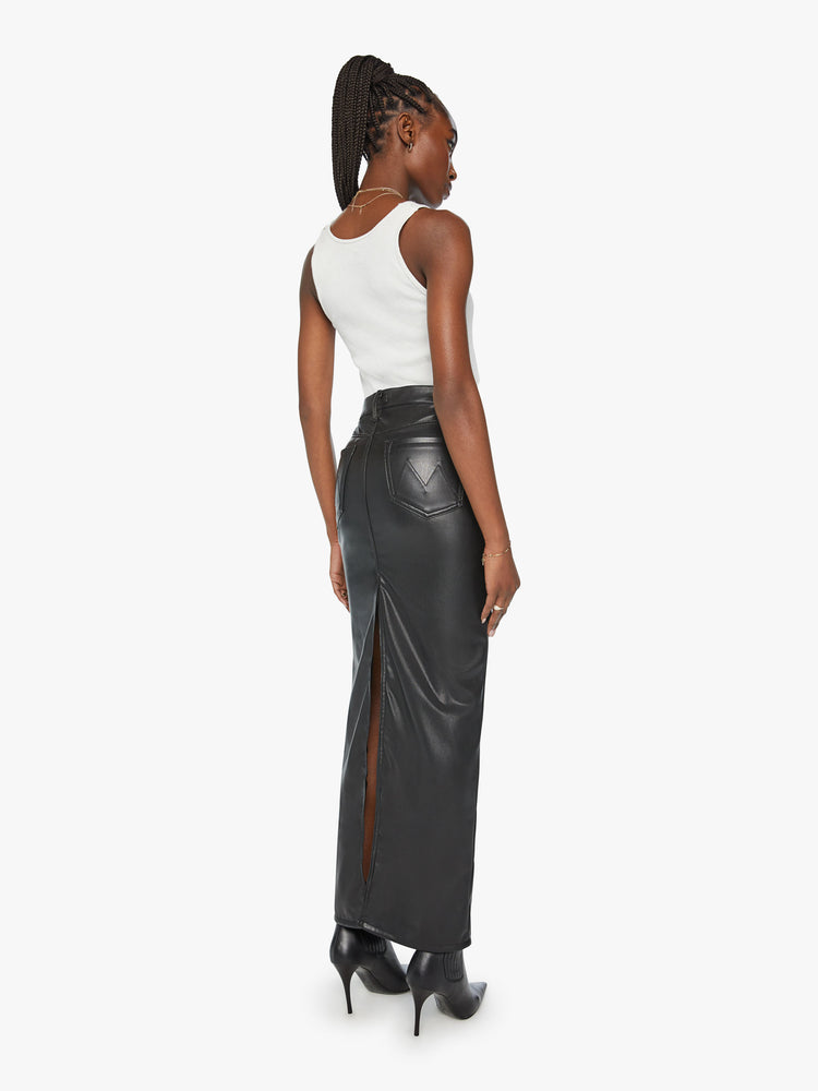 Back view of a womens high rise column skirt in a black faux leather featuring a high back slit..