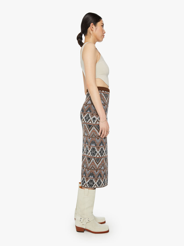 Side view of a woman knit midi skirt with a high-rise, thigh-high side slit and a straight fit in metallic shades of brown, grey and white.