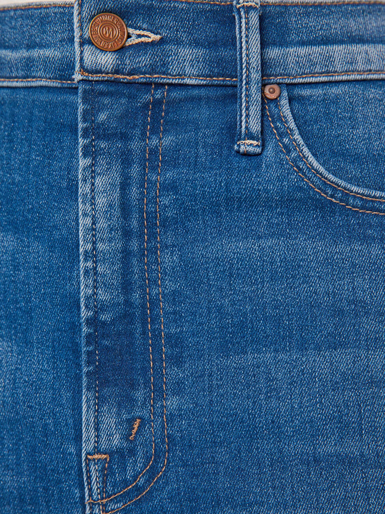 Swatch view of a woman denim pencil skirt with a high rise, narrow fit and a thigh-high front slit in a mid blue wash.