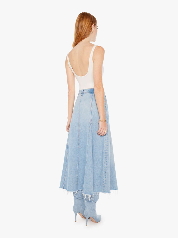 Back view of a womens light blue wash denim skirt featuring a high rise and frayed hem.