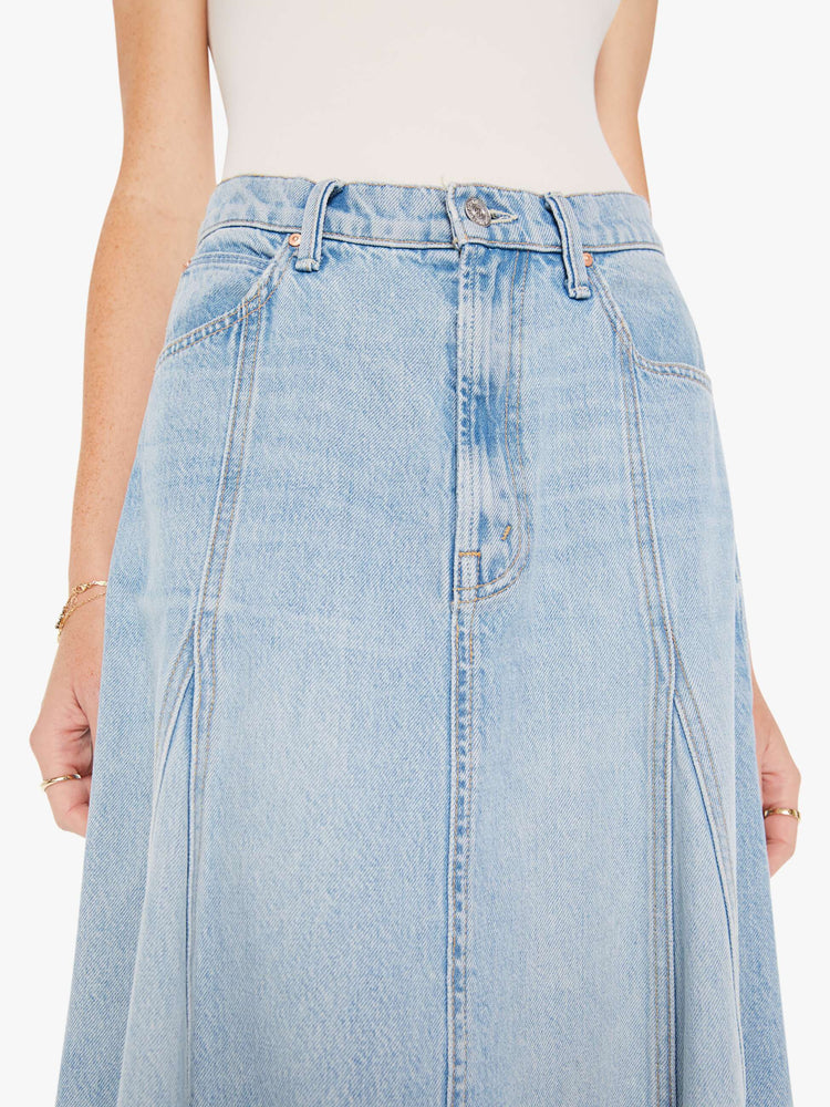 Front close up view of a womens light blue wash denim skirt featuring a high rise and frayed hem.