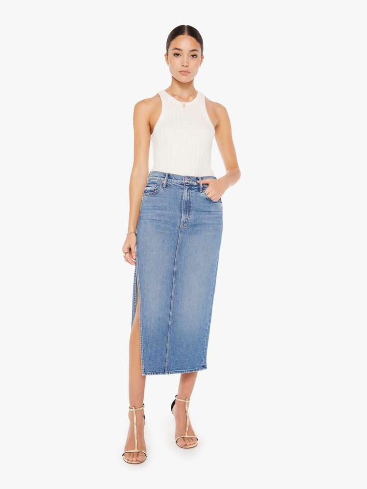 Front view of a womens medium blue wash denim skirt featuring a high rise and a high side slit.