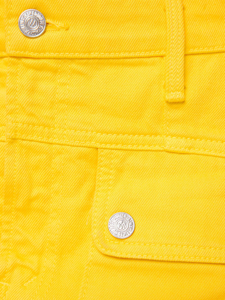 Swatch view of a woman in a yellow mini skirt with patch pockets, a zip fly and playfully short hem.