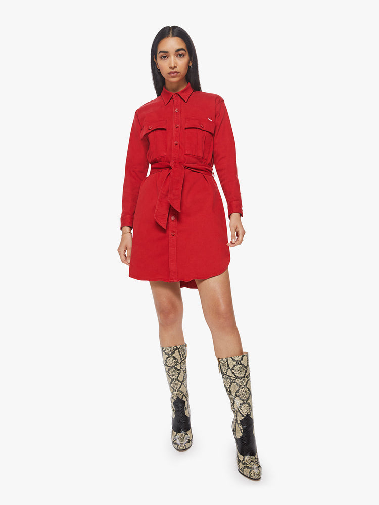 Front view of a woman red mini shirt dress with long sleeves, a collared neck, buttons down the front and a tied belt at the waist.