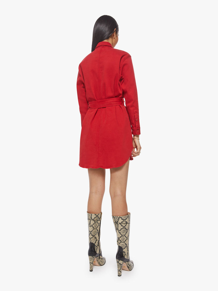 Back view of a woman red mini shirt dress with long sleeves, a collared neck, buttons down the front and a tied belt at the waist.