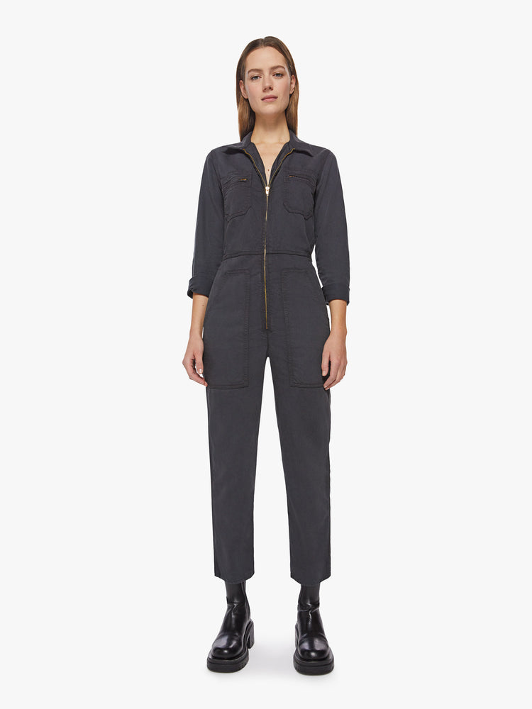 Front view of a woman faded black workwear-inspired zip-up jumpsuit with a collared neck, patch pockets, high rise elastic waistband, 3/4-sleeves and an ankle-length inseam.