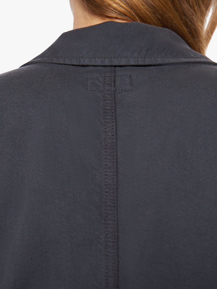 Back close up view of a woman faded black workwear-inspired zip-up jumpsuit with a collared neck, patch pockets, high rise elastic waistband, 3/4-sleeves and an ankle-length inseam.