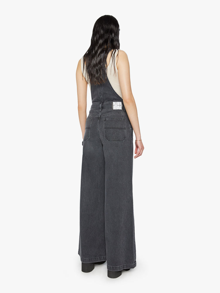 Back view of a women wide leg overalls with a super high rise and a hammer loop and a 32-inch inseam.