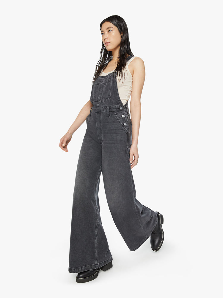 Walking view of a women wide leg overalls with a super high rise and a hammer loop and a 32-inch inseam.