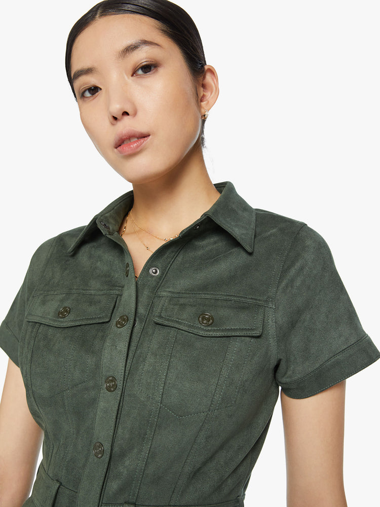 Close up view of a woman collared mini dress with short sleeves, patch pockets and snaps down the front in a deep green hue.