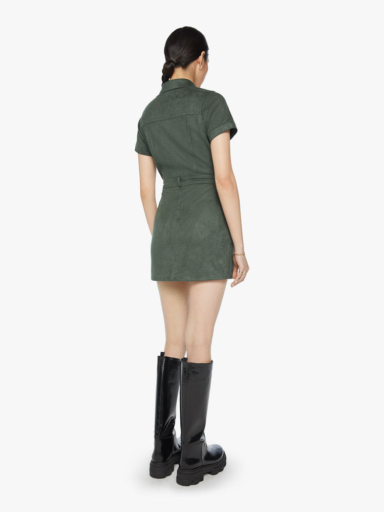 Back view of a woman collared mini dress with short sleeves, patch pockets and snaps down the front in a deep green hue.