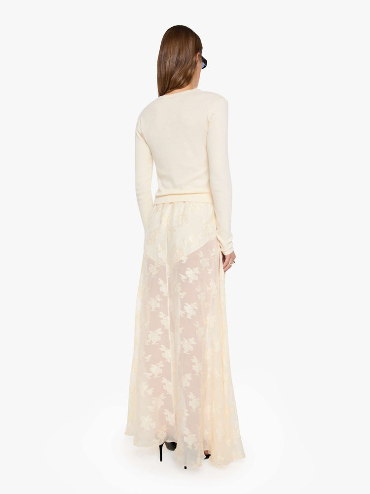 Back view of a woman in a sheer maxi skirt with an elastic waistband, sewn-in mini shorts and a flowy, ankle-length hem.