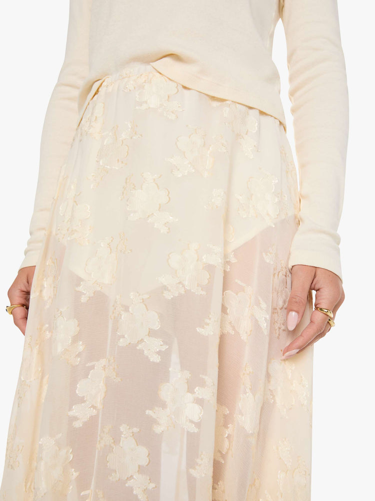 Close up view of a woman in a sheer maxi skirt with an elastic waistband, sewn-in mini shorts and a flowy, ankle-length hem.