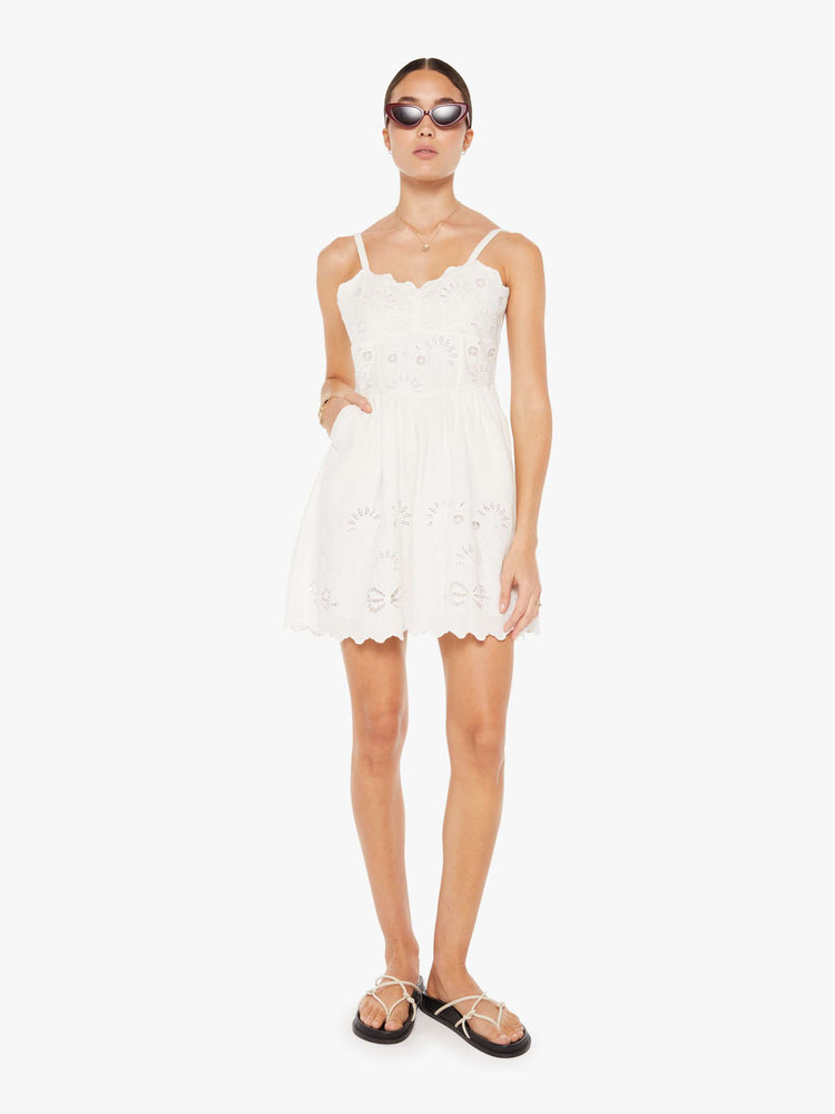 Front view of a womens white mini dress featuring embroidered details and eyelets.
