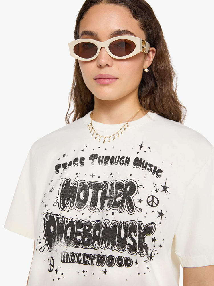 WOMAN close up view in a  white top with a MOTHER's spin on the classic Amoeba Music logo in black on the front.