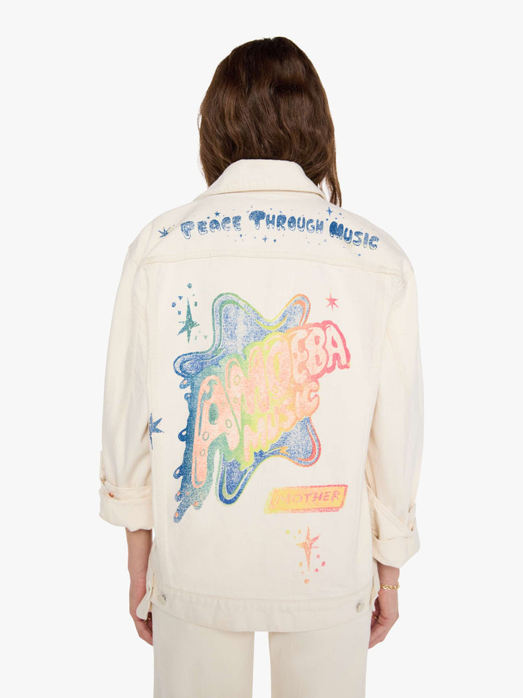 WOMAN back view in a  creamy white with tonal hardware, patches and pins denim jacket with drop shoulders, front patch pockets and a boxy fit.