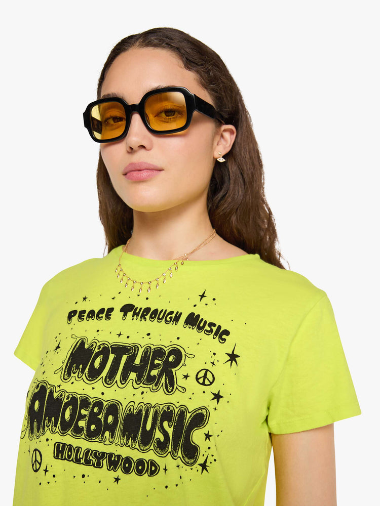 Front close up view of a woman in a lime green top features MOTHER's spin on the classic Amoeba Music logo in black on the front.
