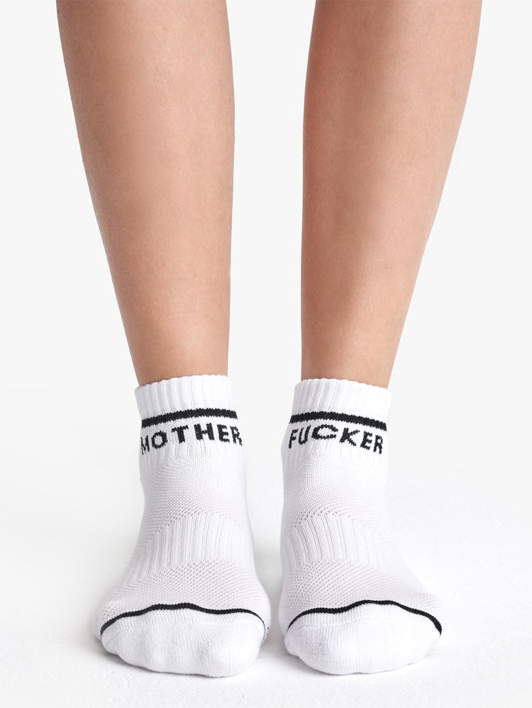 Front view of a pair of white ankle socks with the words "MOTHER" "FUCKER".