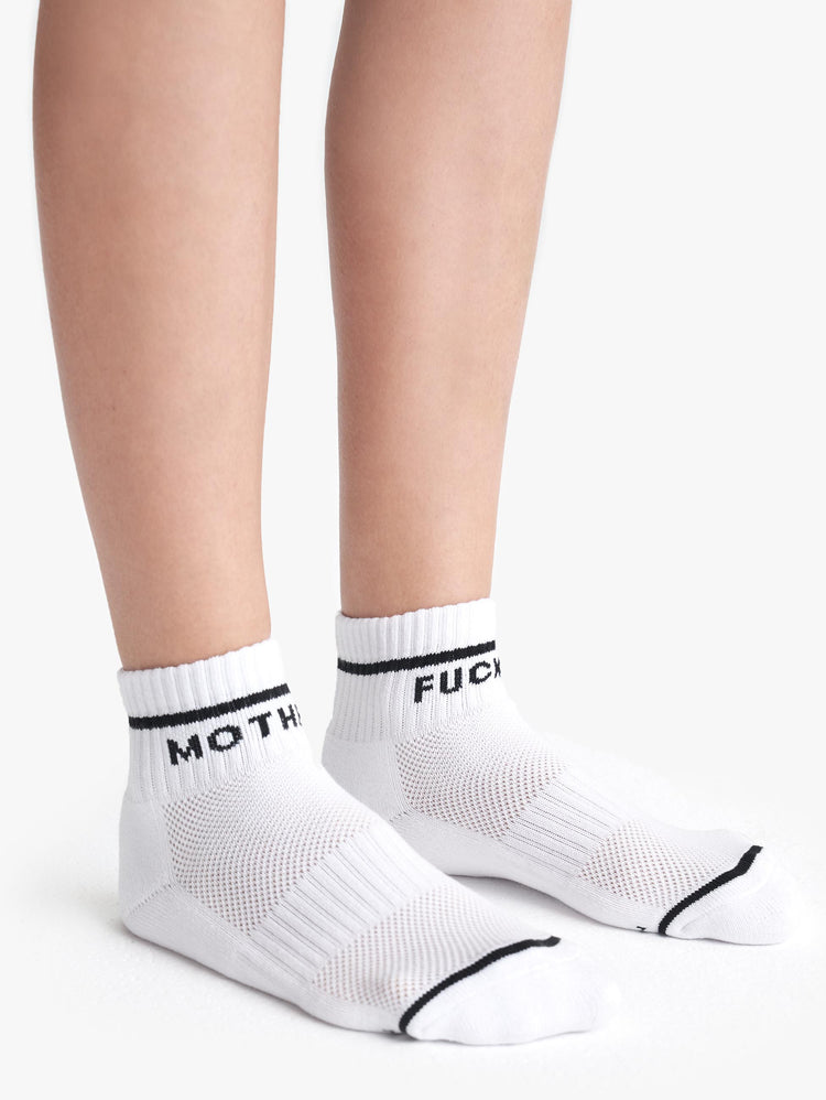 Side view of a pair of white ankle socks with the words "MOTHER" "FUCKER".