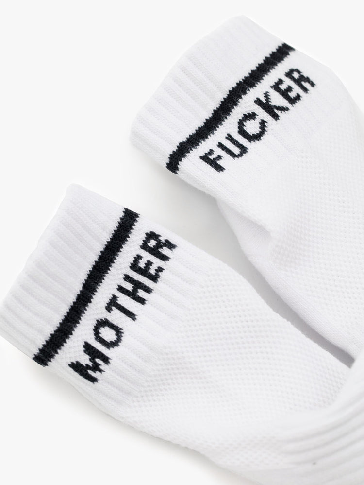 Front close up  view of a pair of white ankle socks with the words "MOTHER" "FUCKER".