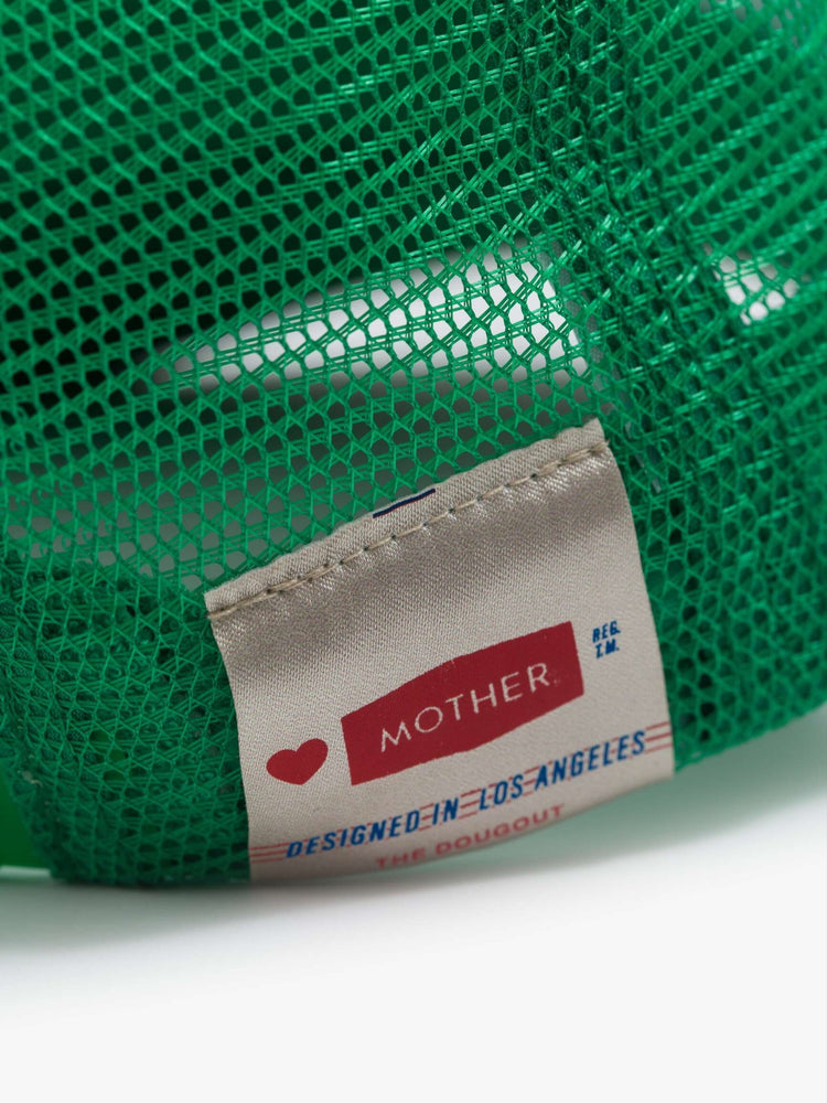 Close up image of a green trucker hat with a white "MOTHER" label sewn on the back.