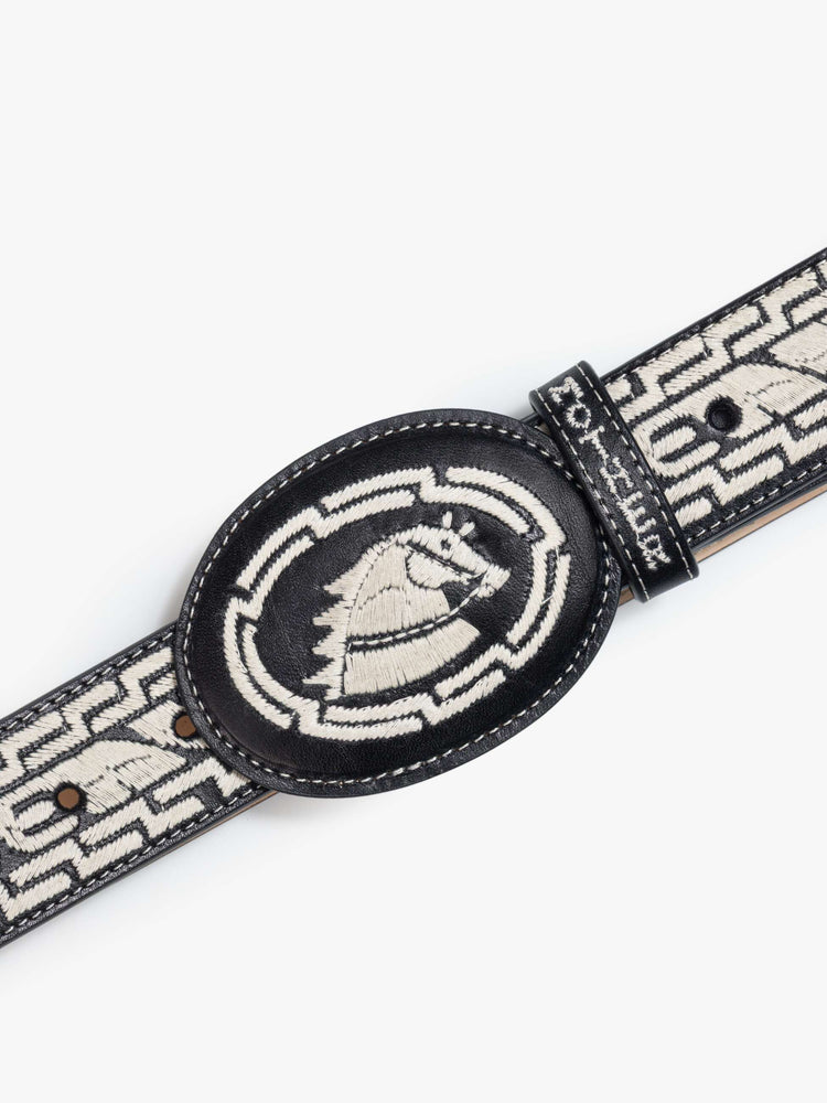 Buckle close up view of leather belt with an oversized buckle and stitched details.