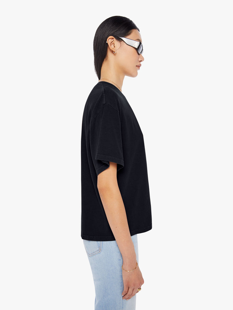 Side view of a woman wearing a black oversized tee.