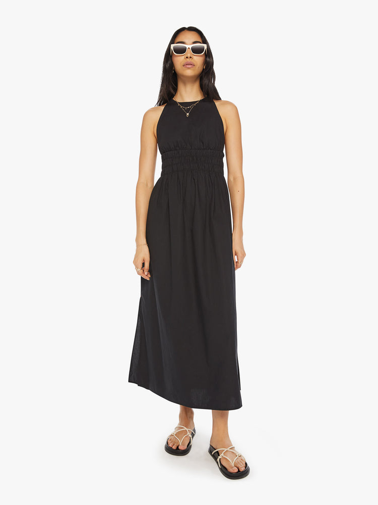 Front view of a woman maxi dress in black, sleeveless dress has a crew neck, thick gathered waistband and an ankle-grazing hem.