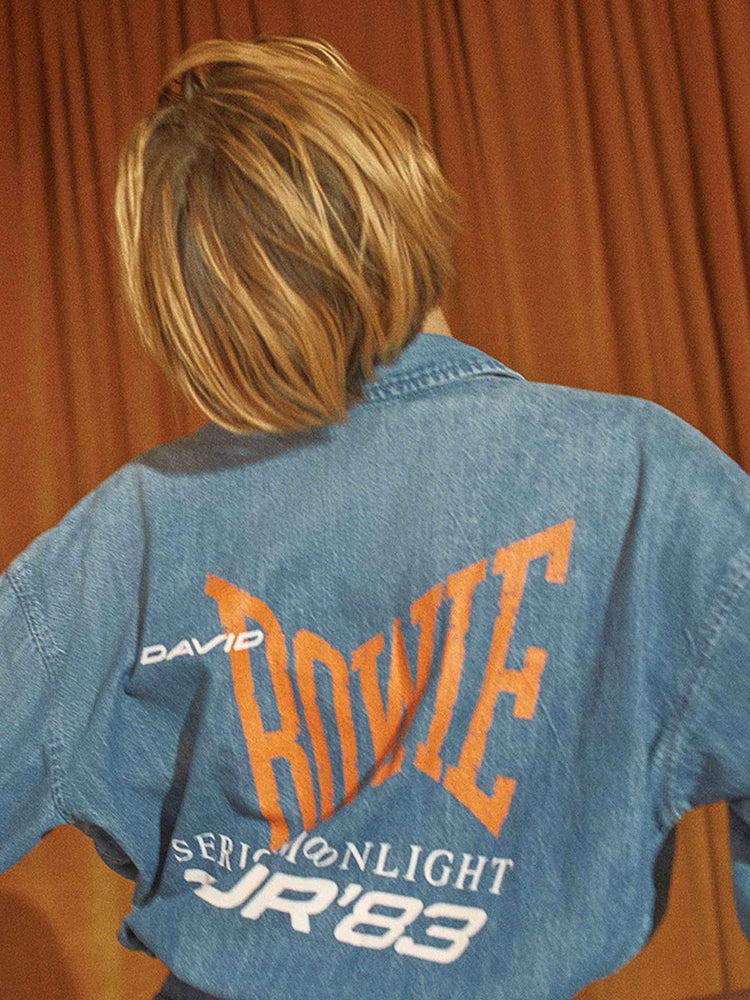 Bowie editorial image of a woman wearing a blue denim shirt featuring a Bowie graphic across the back.
