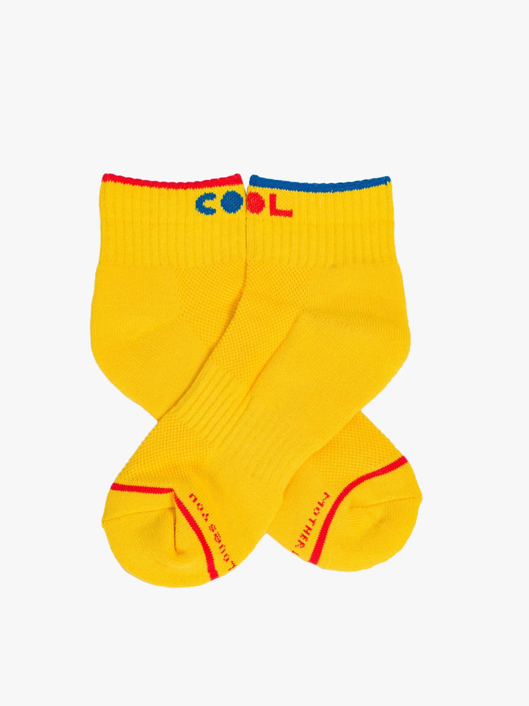 Flat aerial view of a pair of yellow ankle length socks with the word COOL in both red and blue.