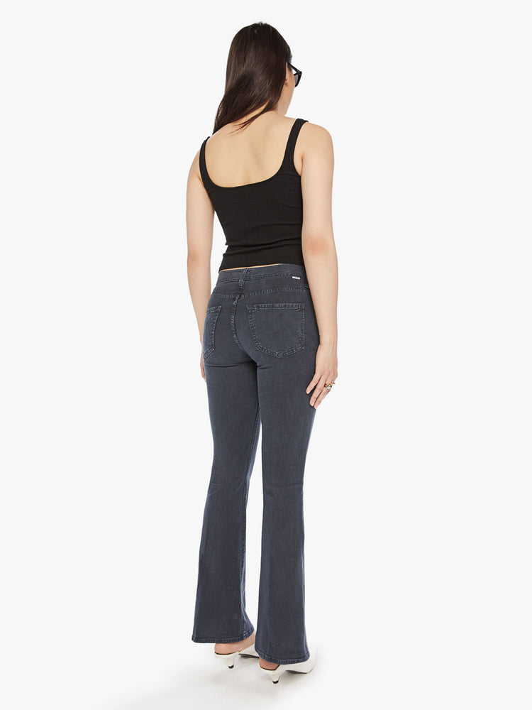 Back view of a womens mid rise flare jean in a faded black wash and clean hem.