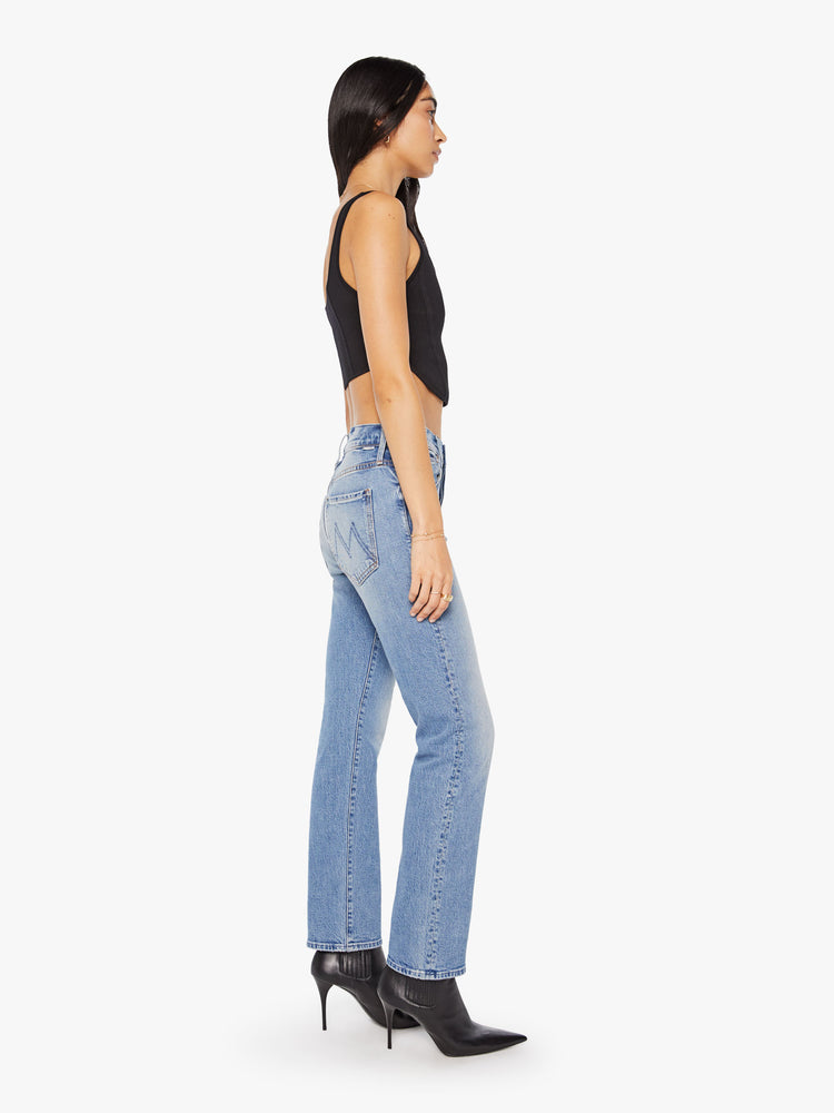 Side view of a woman in midblue straight-leg was adopted from our men’s line and features a mid rise, button fly, low-set back pockets, a 29-inch inseam and a clean hem.