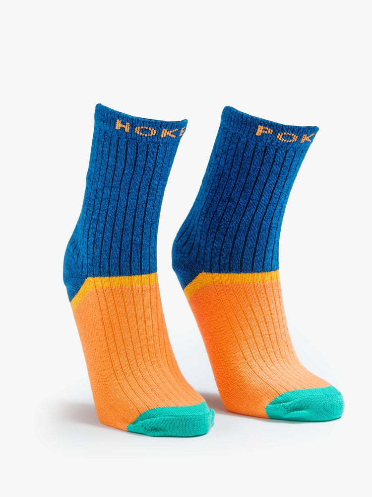 Flat view of Hokey Pokey a pair of navy, orange and teal tube socks with text across the top.