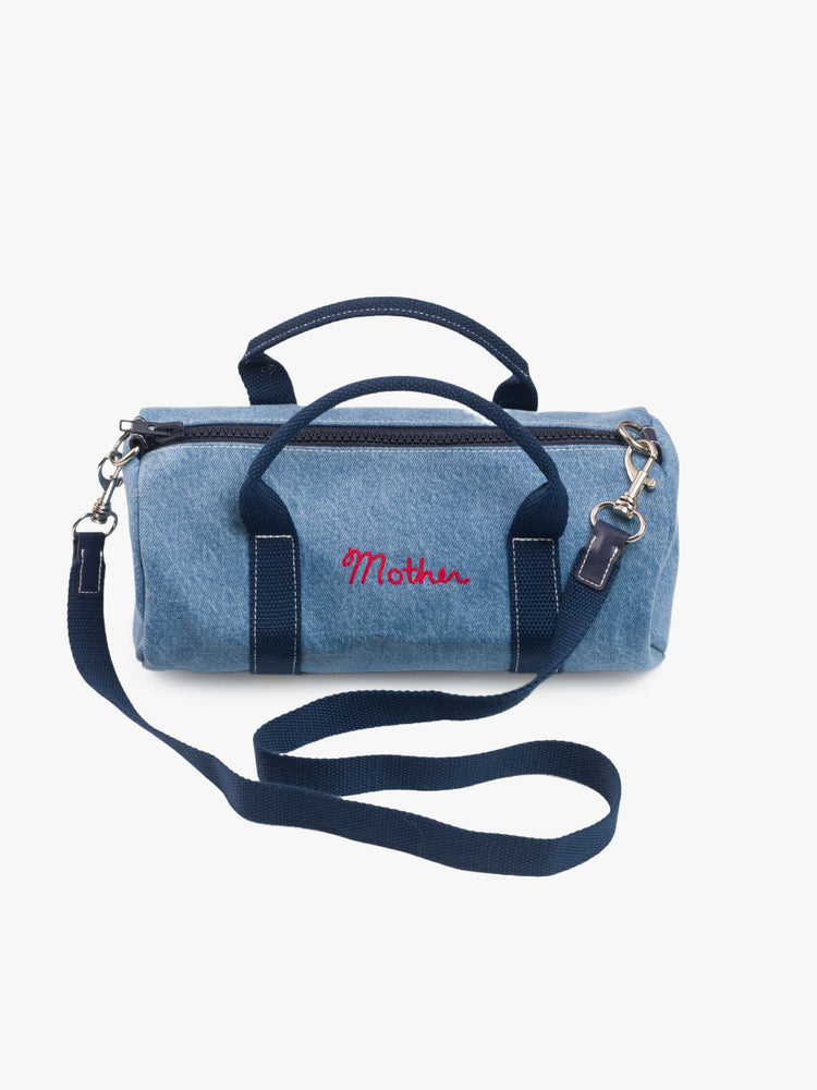 Front view of a faded blue with navy stripes and MOTHERS name embroidered in red across the front  mini bag with a top handle, optional shoulder strap and duffle-bag inspired design. 
