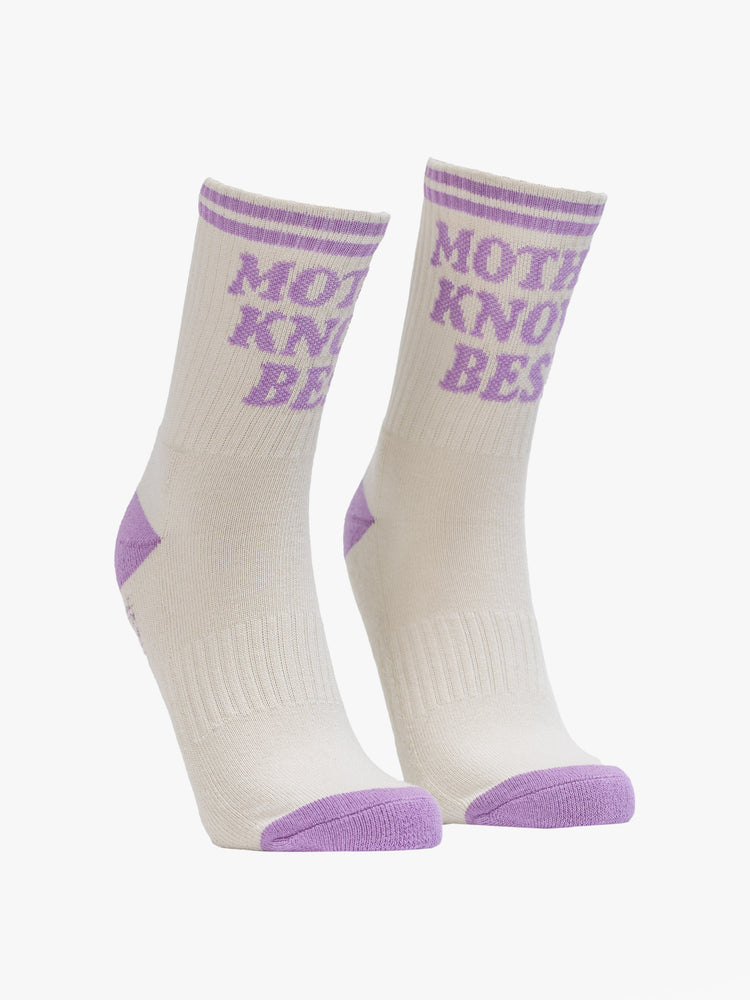 Side angle view of a vintage tube sock in cream with lavender lettering.
