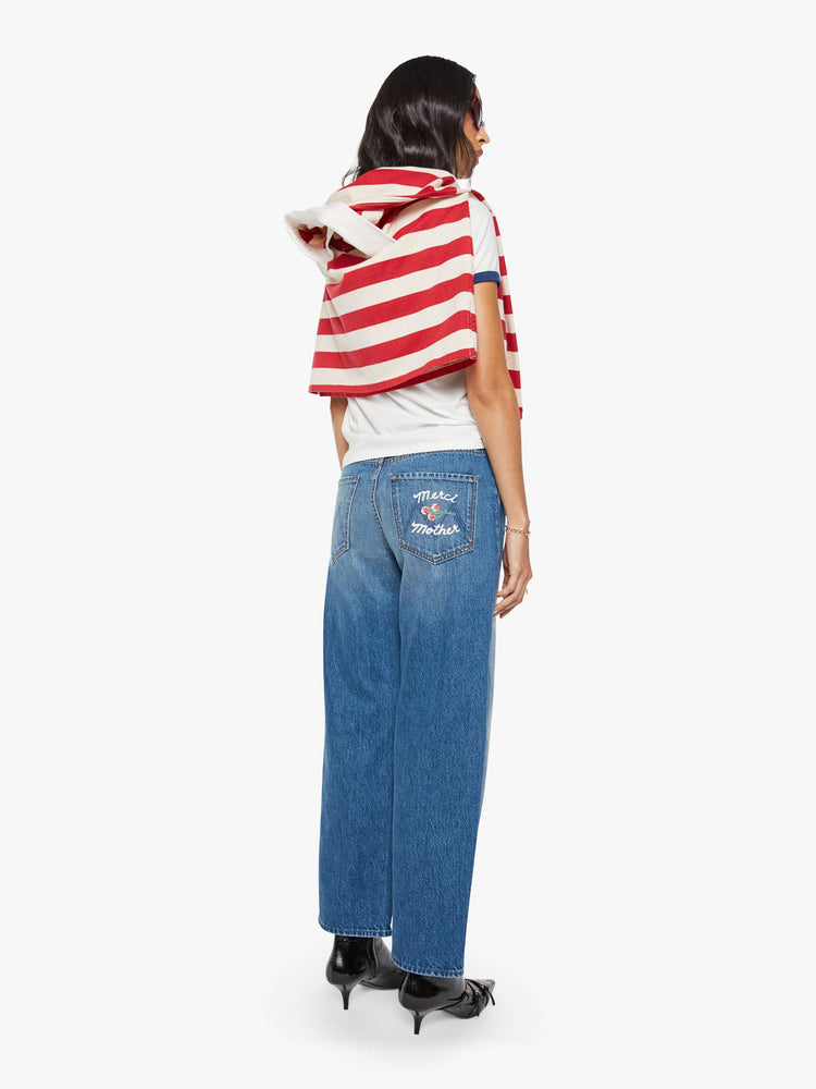 Back view of a woman in a medium blue wide-leg jeans are designed to sit lower on the hips with a zip fly and a clean ankle-length inseam. 