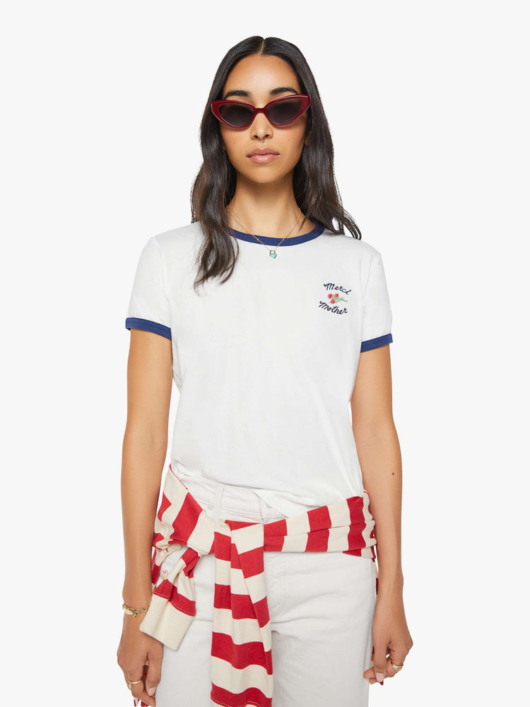 Front view of a woman in a short sleeve tee is made from 100% supima cotton in white with navy trim, and features embroidered text in navy and a small bouquet on the chest.