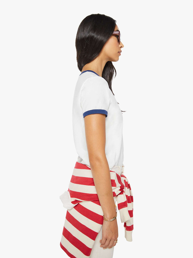 Side view of a woman in a short sleeve tee is made from 100% supima cotton in white with navy trim, and features embroidered text in navy and a small bouquet on the chest.