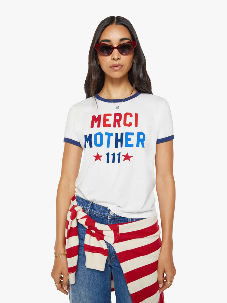 Front view of a woman in a short sleeve tee is made from 100% supima cotton in white with navy trim, and features an oversized text graphic in red and blue on the front.