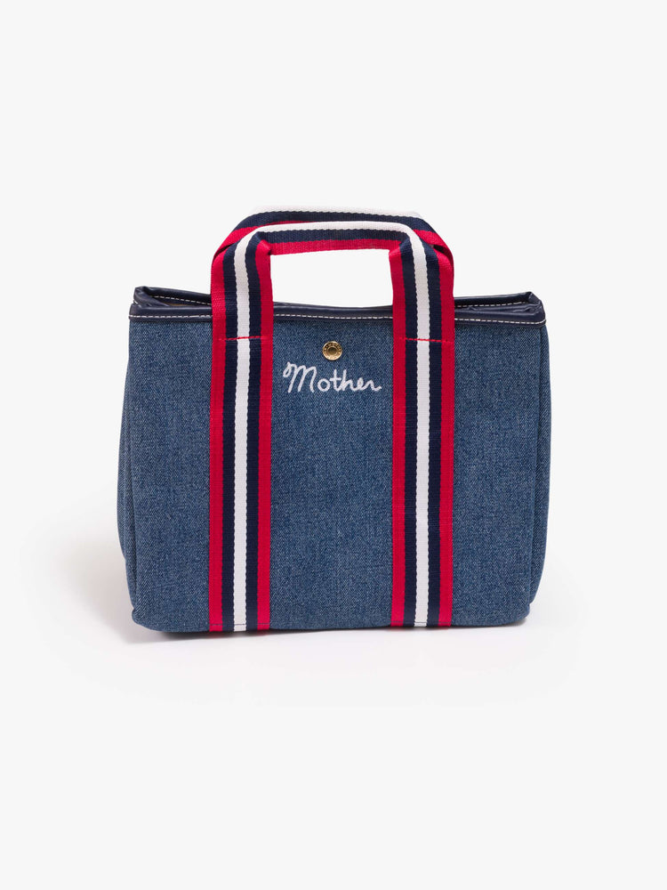 Flat view of a classic blue denim with red and white trim, top handles, an optional 34-inch shoulder strap, a snap closure and MOTHER embroidered across the front in white.