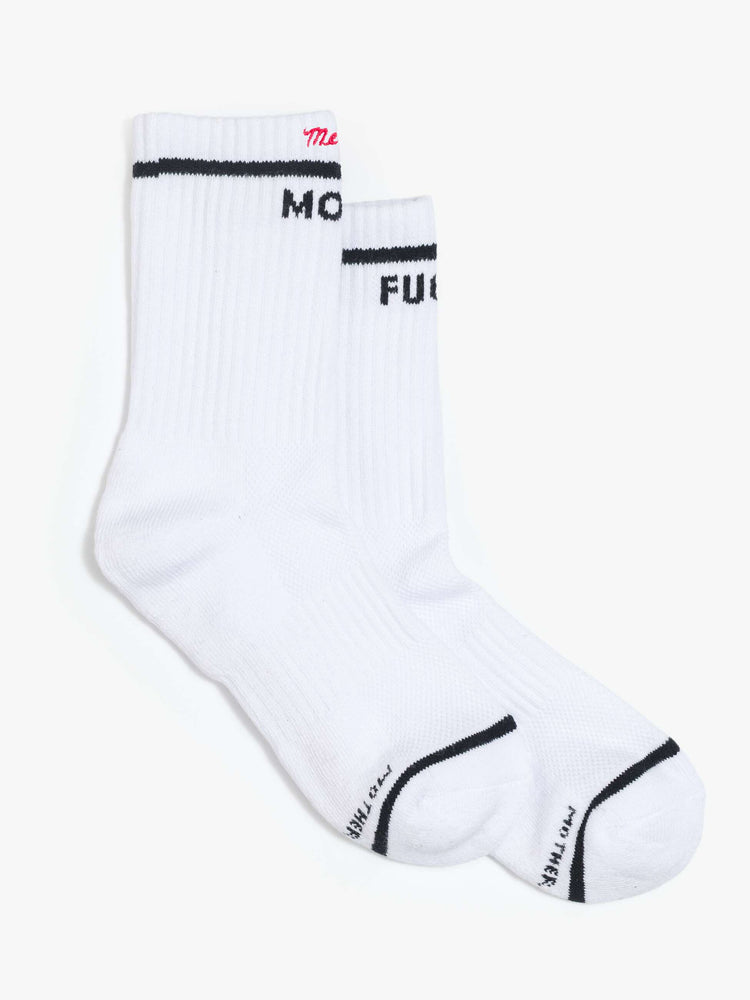 Flats side view of white with bold lettering in black socks and "Merci" embroidered in red at the hem. 