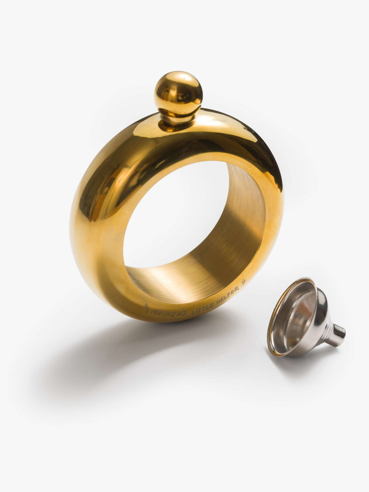 A brass-toned flask is designed with a rounded twist-on lid and a cheeky engraved message across the base.