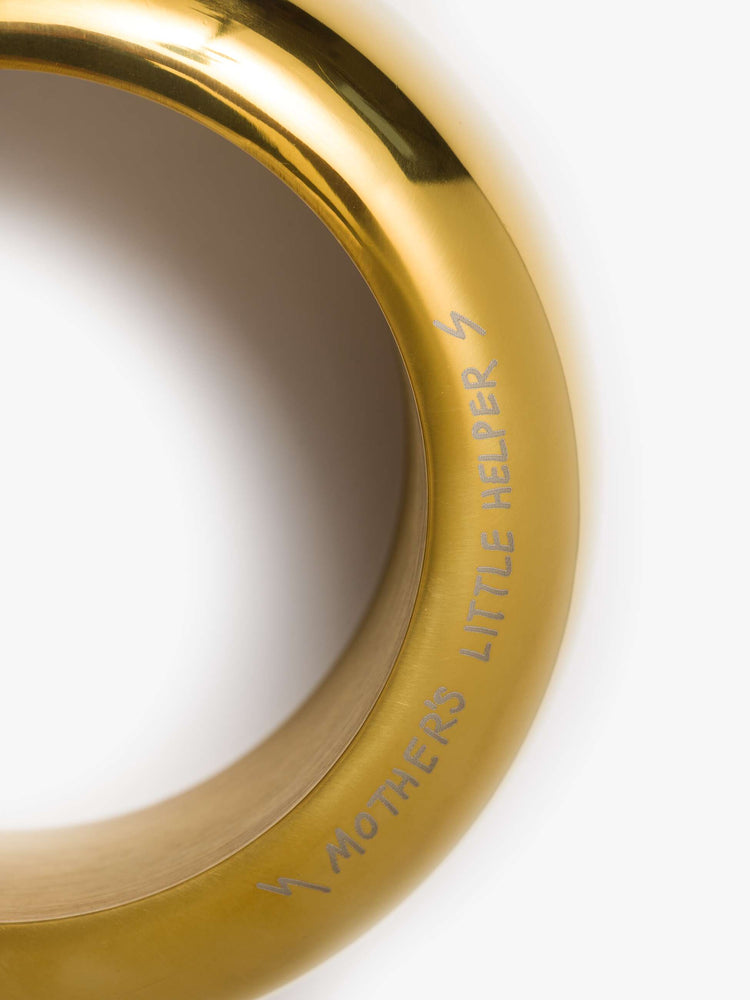 A brass-toned flask is designed with a rounded twist-on lid and a cheeky engraved message across the base.