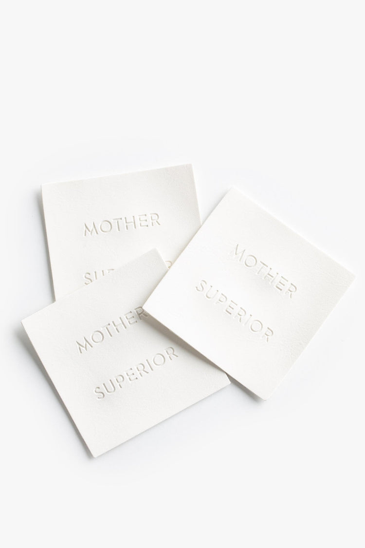 A pile of white square labels reading "MOTHER SUPERIOR".
