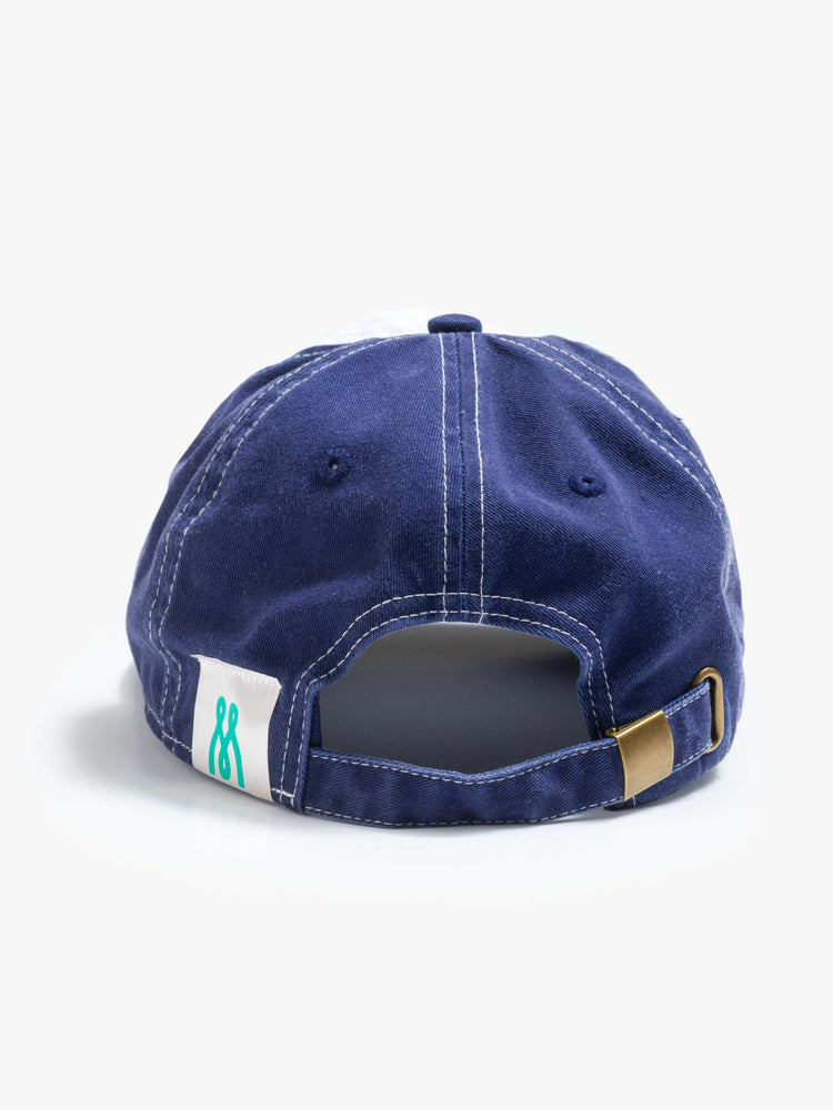 Flat back view of a woman dad hat designed in white and navy 100% cotton with white stitching and an M embroidered in teal on the front.
