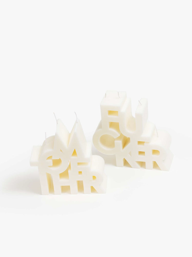 Image of two off white candles made up of stacked letters reading "MOTHER" and "FUCKER".